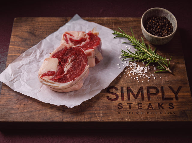 Rolled ribeye cap on butcher paper with rosemary and black pepper