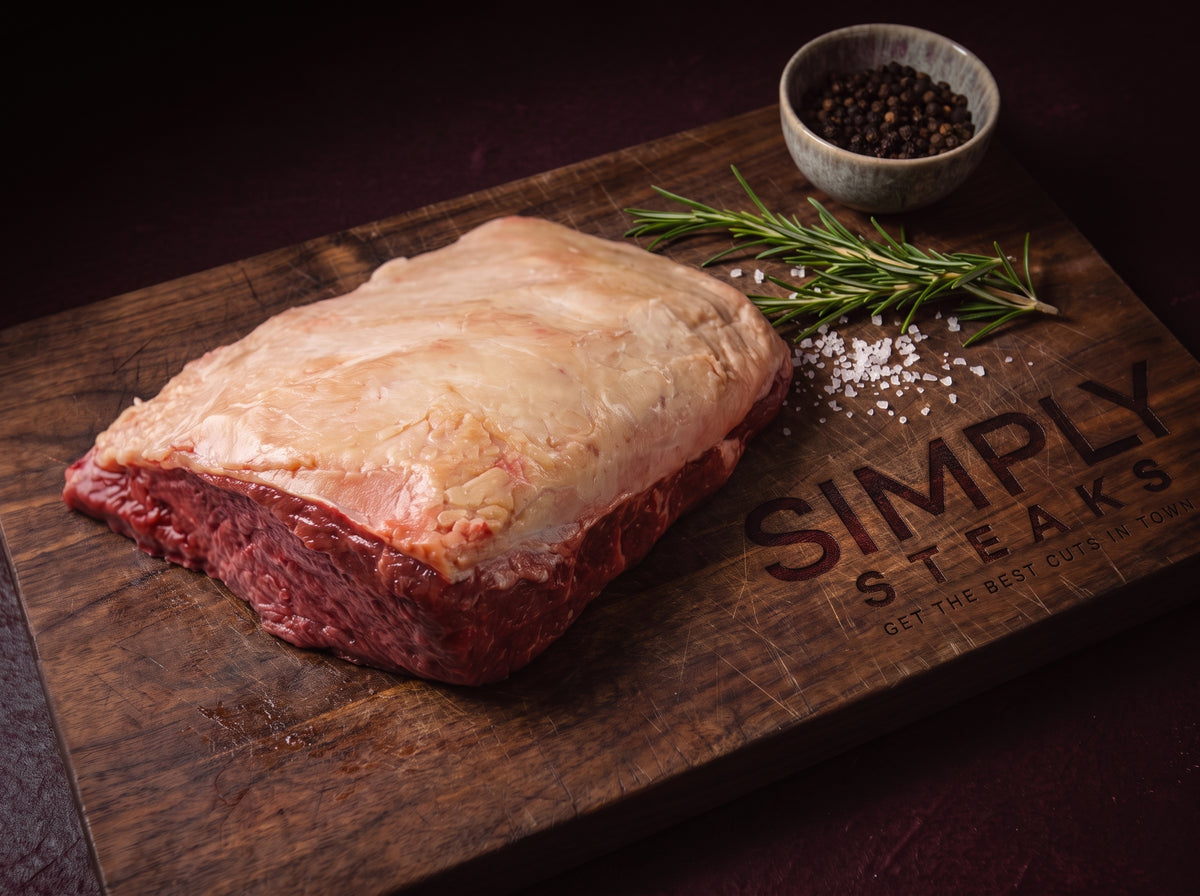 Picanha with its fat cap on a Simply Steaks wooden board