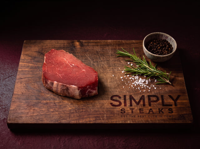 Raw fillet steak on a Simply Steaks wooden board with rosemary